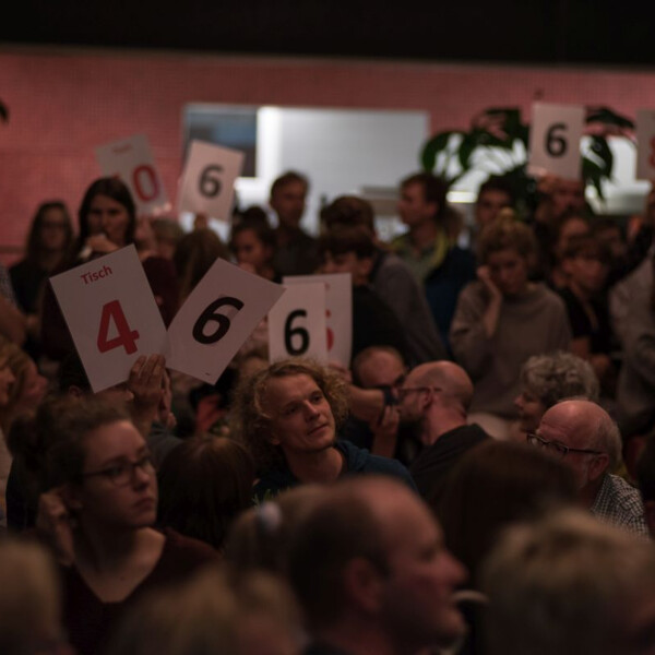 Besucher halten Zahlen in die Luft.